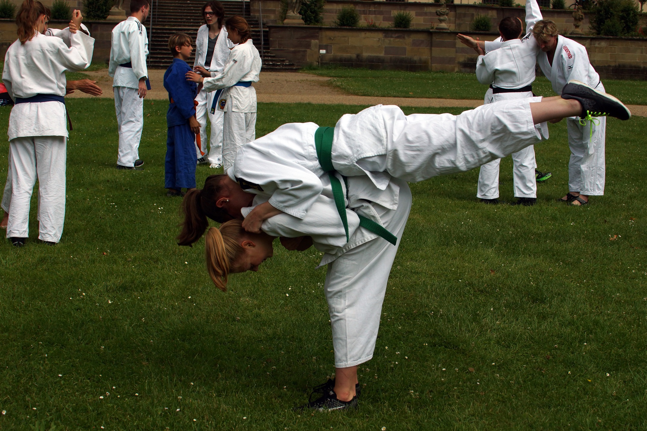 Bild: Einige Judokas stehen im Schlosspark und machen verschiedene Übungen.